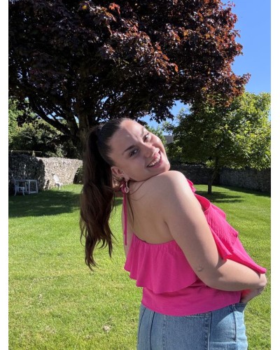 Haut rose à volants avec une fleur